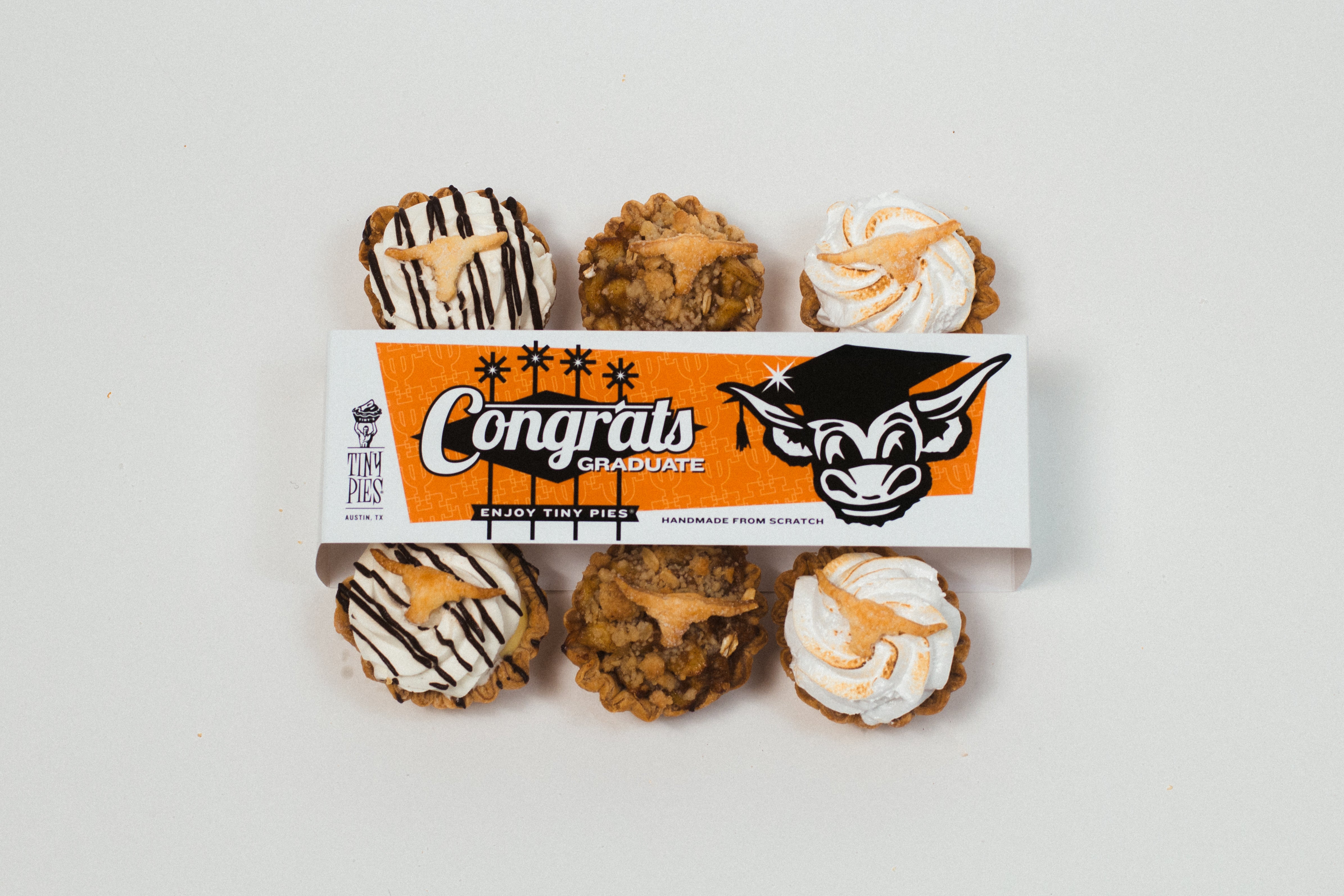 Specialty UT Graduation Tiny Pies® wrapped in a Longhorn bellyband and topped with miniature longhorns.