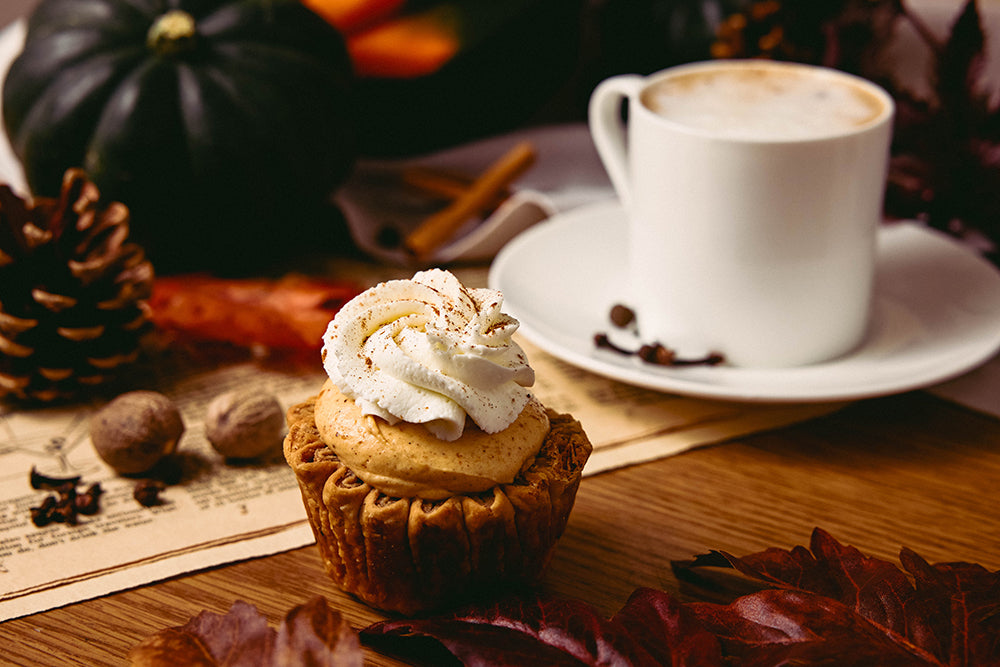 Mini Pumpkin Pie with whipped cream next to a cup of chai